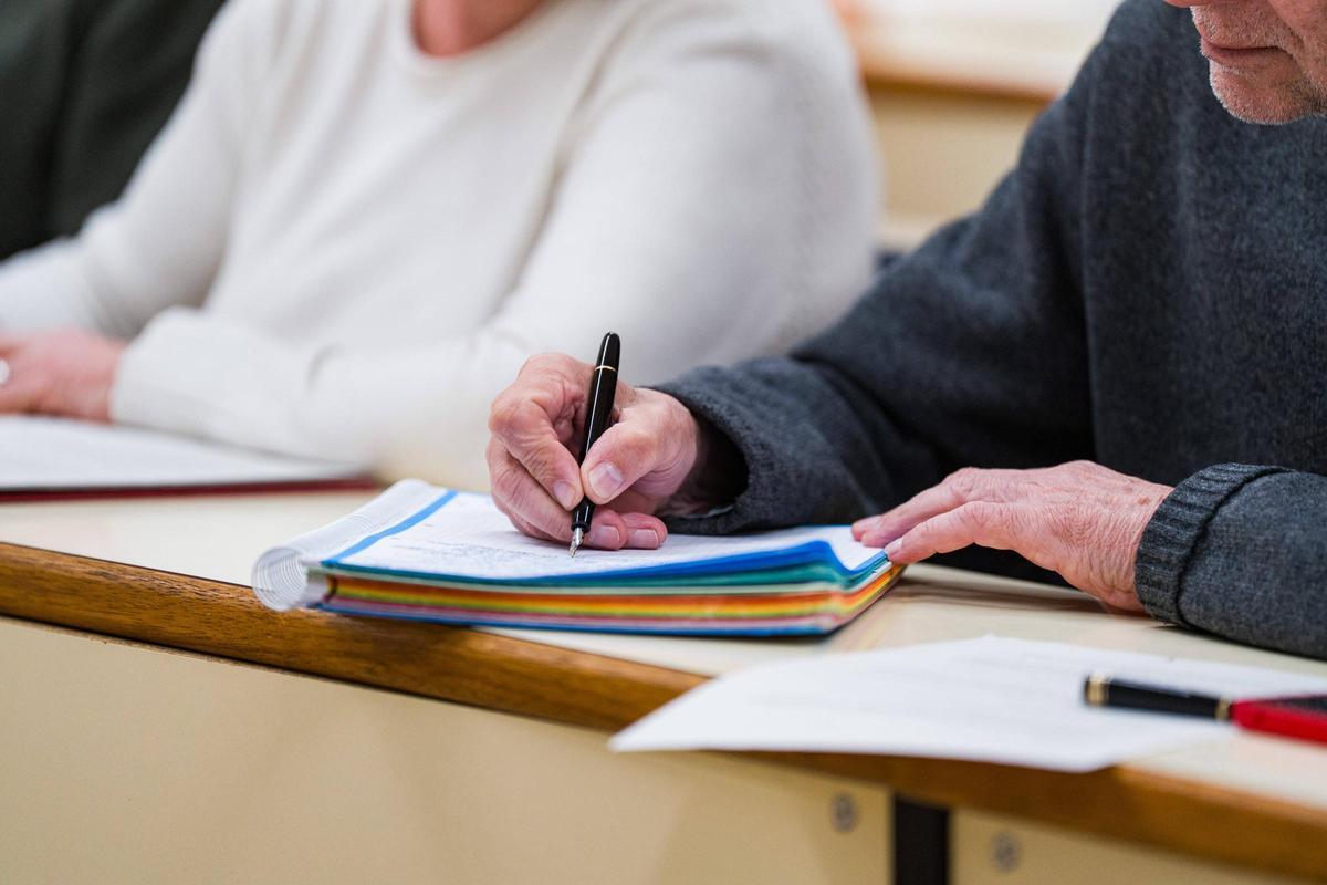 Un alumno de la Universitat de l'Experiencia toma apuntes en clase.