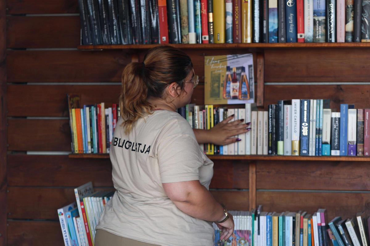 Sara mostrando ejemplares de la estantería.