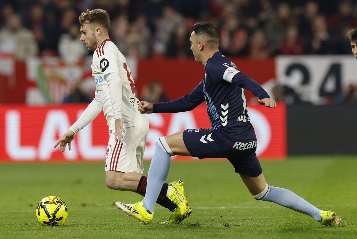 El centrocampista del Sevilla Peque Fernández (i) se escapa de Iago Aspas.