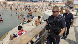 Un policía fuertemente armado patrulla por la playa de Los Catalanes, en Marsella.