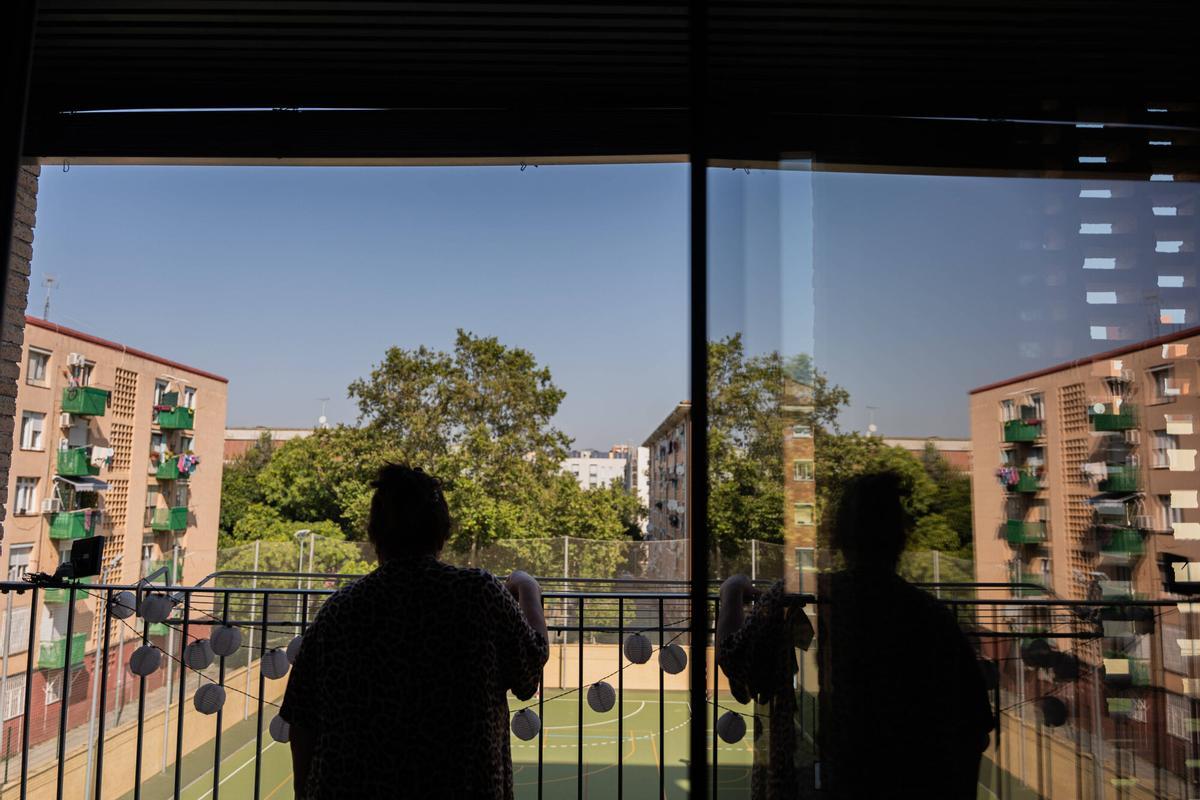 Una vecina asomándose al balcón de su vivienda en el barrio del Besòs i el Maresme, en Barcelona.