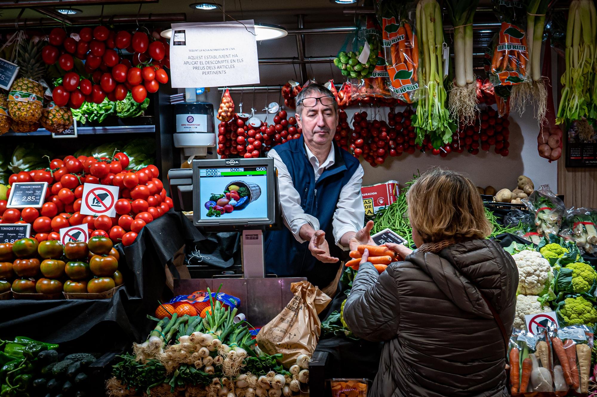 Barcelona 02/01/2023 Economía. Efecto de la rebaja del IVA en los precios de verduras, aceite y leche, en supermercados y en mercados. Ambiente en tiendas de hortalizas en el mercado del ninot. Se observa un papel dónde se indica la apliacación de la rebaja del IVA en dicho establecimiento. AUTOR: MANU MITRU