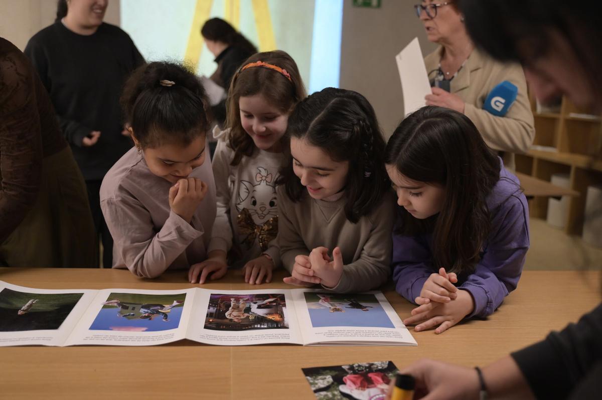 Varias alumnas del CEIP Wenceslao Fernández Flórez viendo el fotolibro finalizado.