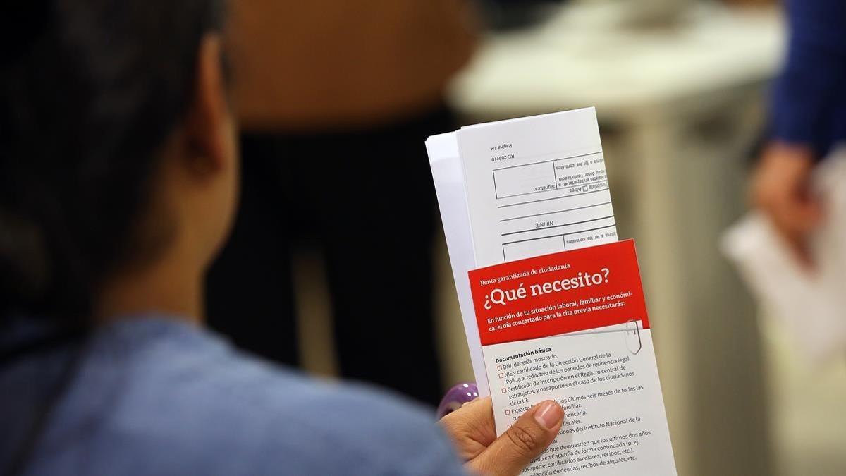 Usuarios en una Oficina de Treball para solicitar la Renta Garantizada de Ciudadanía.
