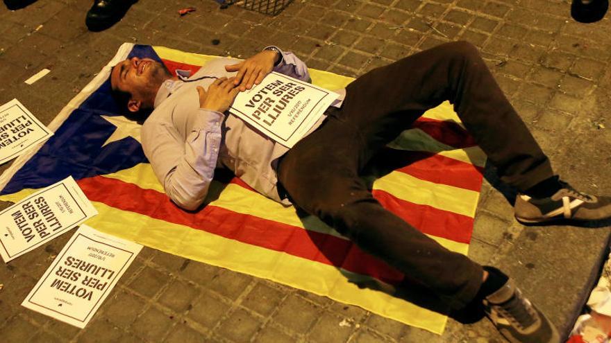 Una manifestant s&#039;estira sobre una estelada a la porta d&#039;Economia.