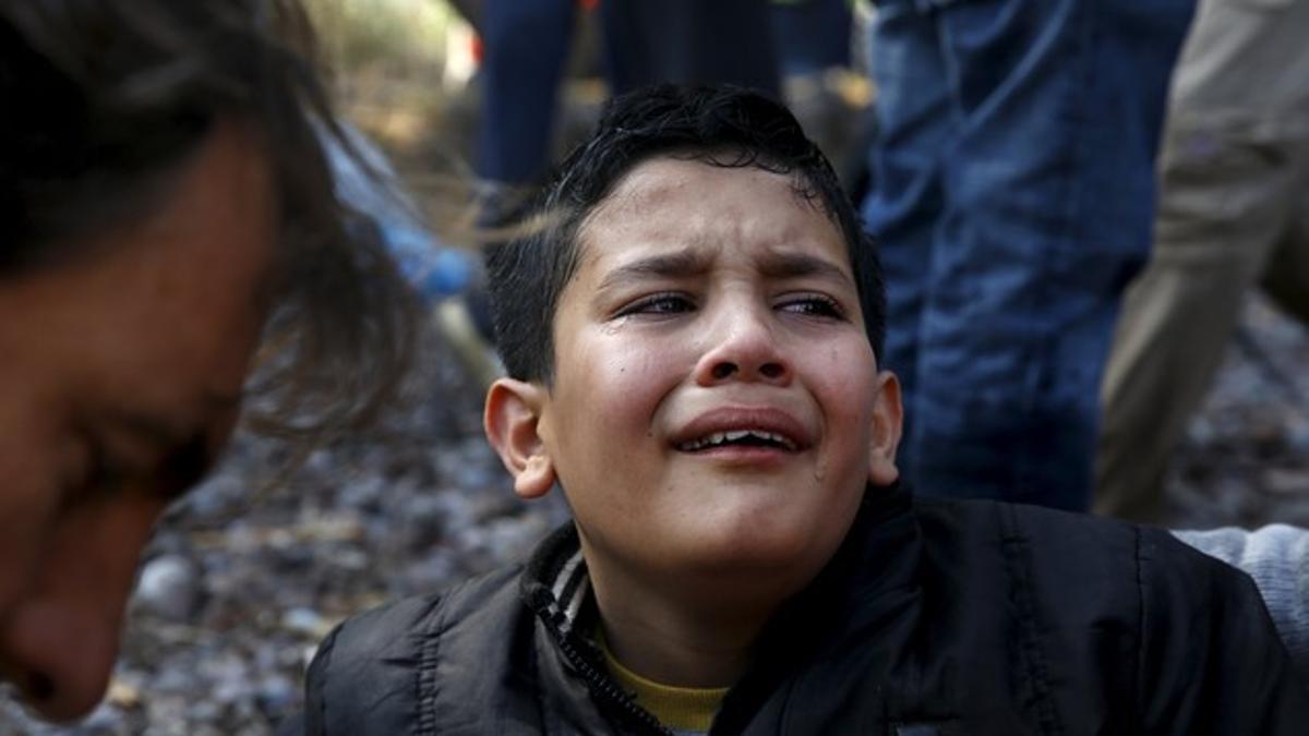 An Afghan migrant boy cries soon after arriving in an overcrowded raft at a beach on the Greek island of Lesbos