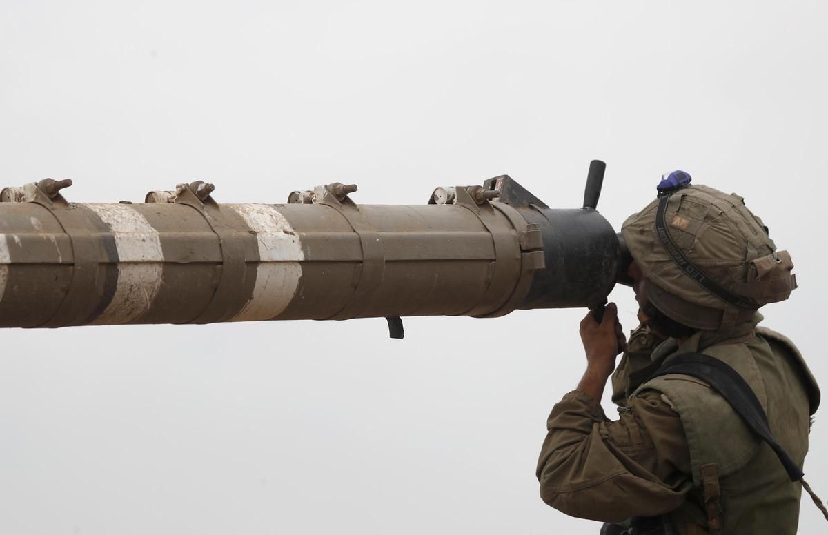 Un soldado israelí inspecciona equipamiento militar, mientras permanece cerca de la frontera con Gaza, al sur de Israel.