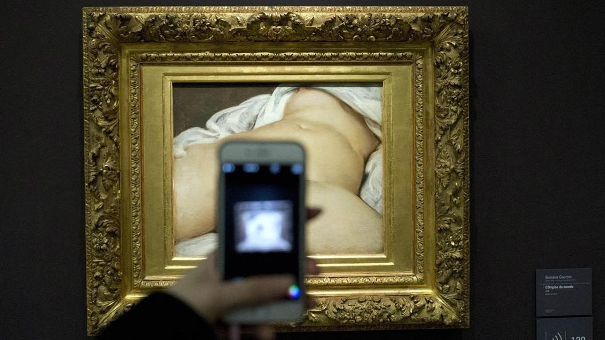 Un visitante toma una foto al cuadro 'El origen del mundo' de Gustave Courbet en el Museo d'Orsay de París.