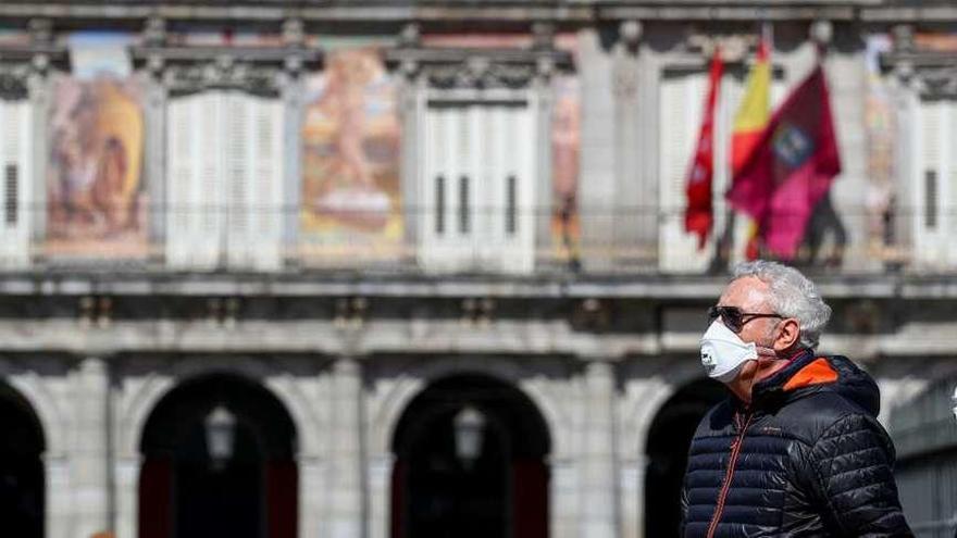 Una pareja con mascarilla, ayer, en la Plaza Mayor de Madrid. // Sergio Pérez