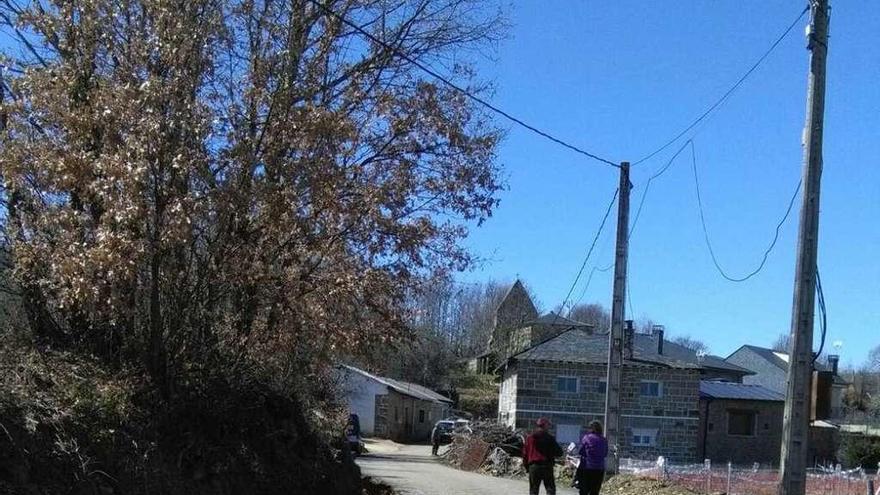 Dos vecinos caminan por la travesía de Villar de los Pisones.