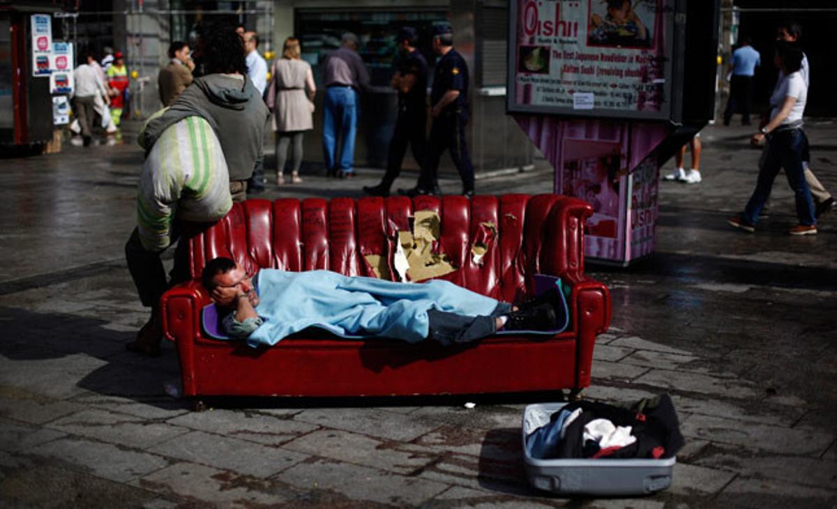 Un home dorm en un sofà a la Puerta del Sol, a Madrid, l’endemà que es desmantellés el campament dels indignats.