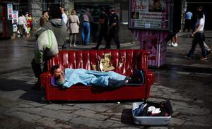 Un home dorm en un sofà a la Puerta del Sol, a Madrid, l’endemà que es desmantellés el campament dels indignats.