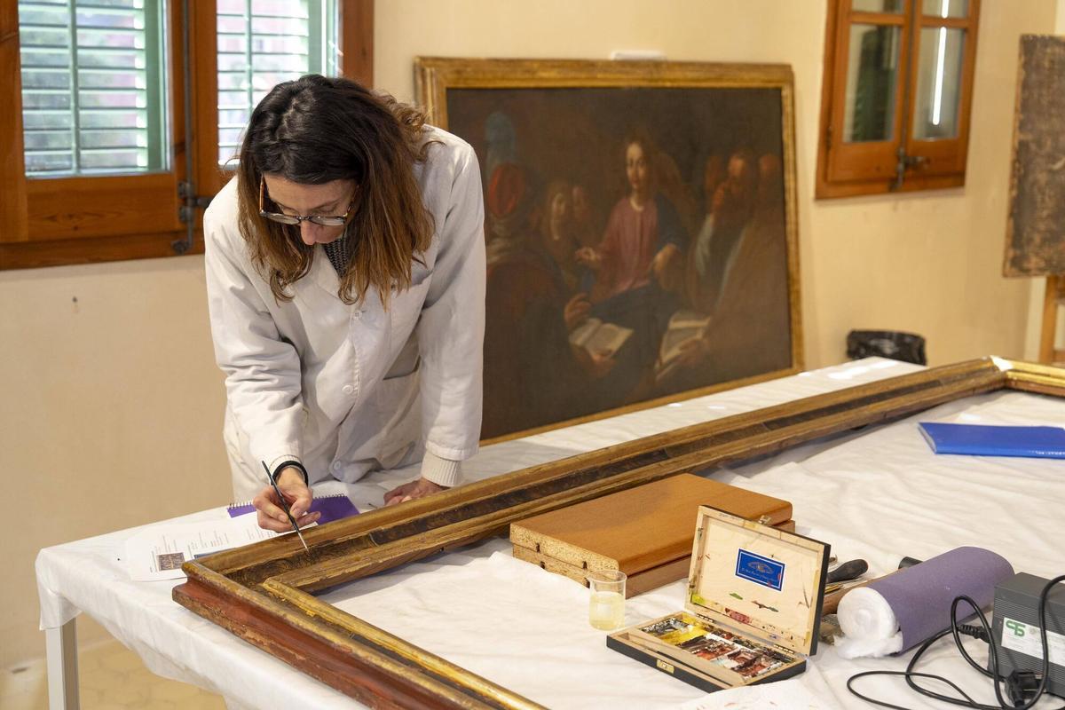 Irene Panadés restaura un marco y, al fondo, una obra de Viladomat, 'Jesús discutiendo en el templo'.
