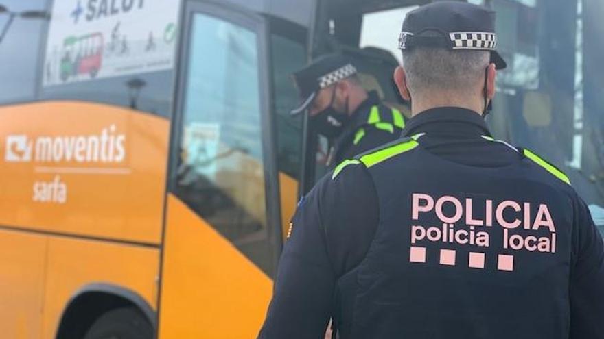 Dos agents revisen un autobús escolar