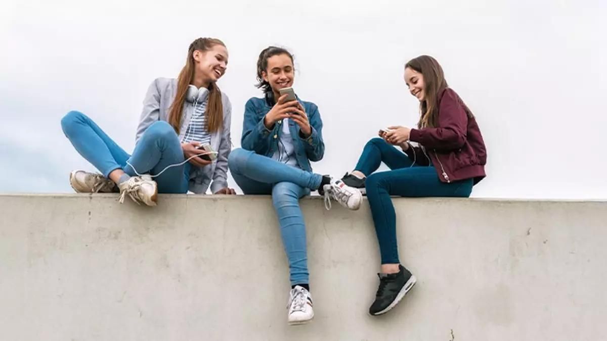 Unas jóvenes realizan un bizum a través de su teléfono móvil