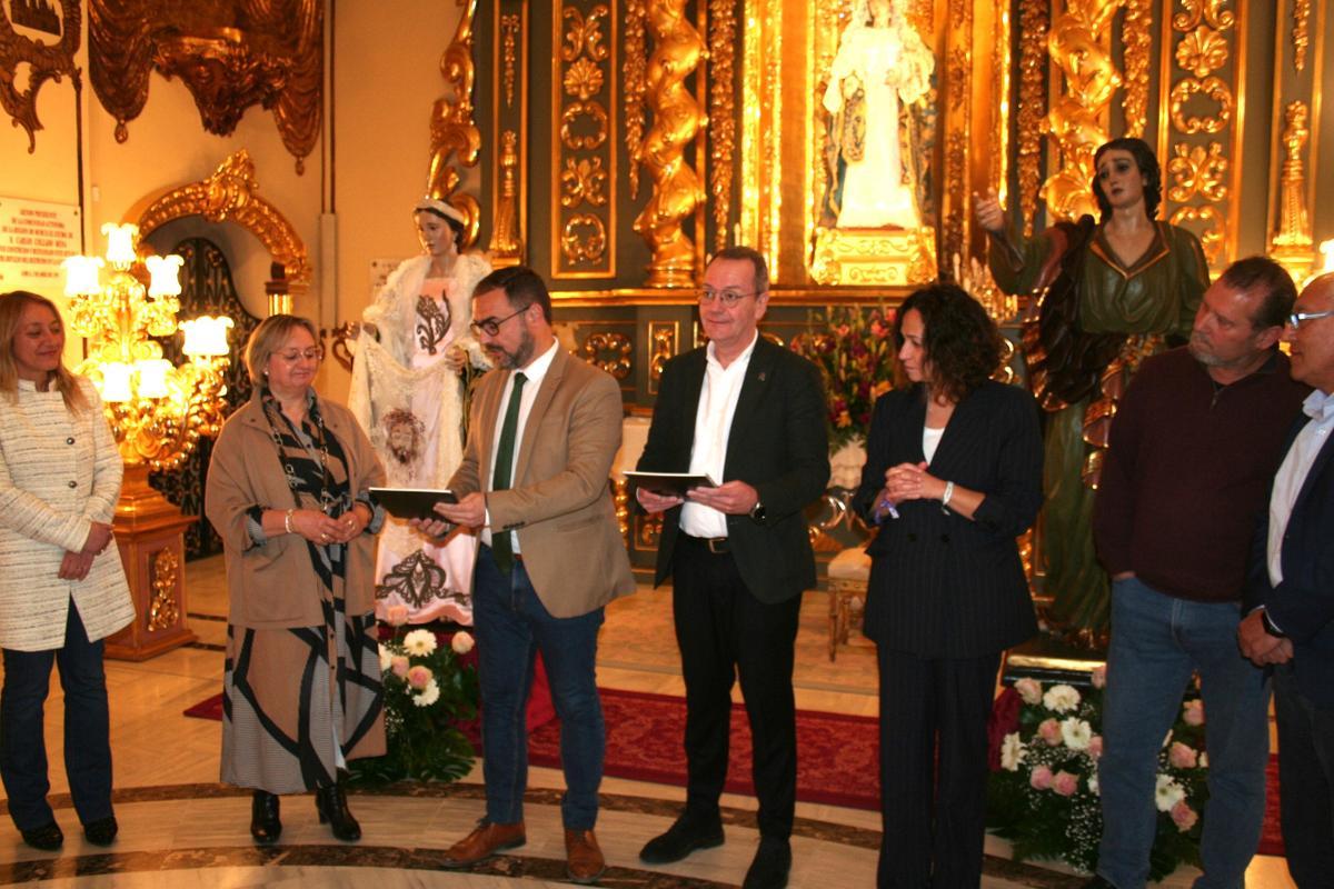 Diego José Mateos entregaba a la presidenta del Coro de Damas de la Virgen de la Amargura, María Jesús Pérez Periago, y al presidente del Paso Blanco, Ramón Mateos, el informe final de restauración de las imágenes de San Juan y la Verónica.