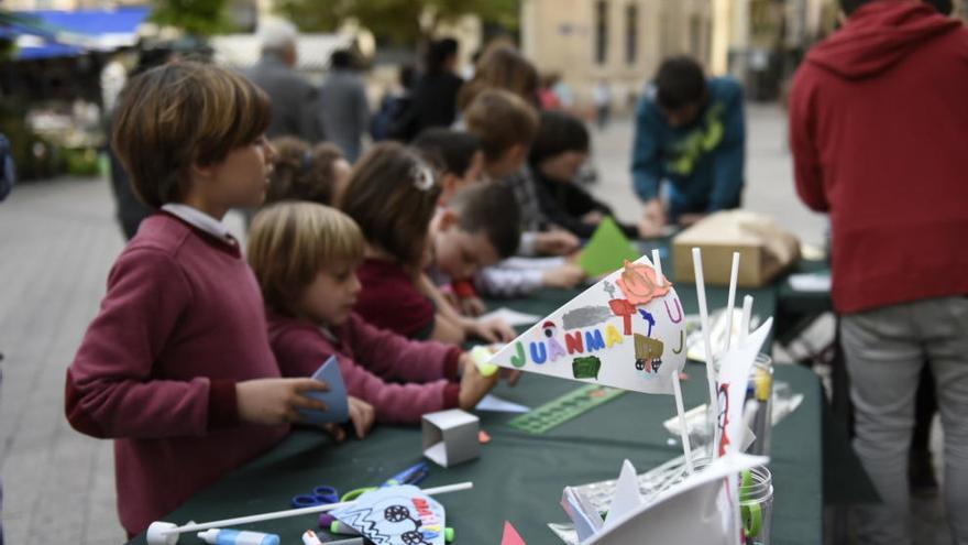 Niños realizan banderines para sus bicis en la plaza de Santo Domingo.