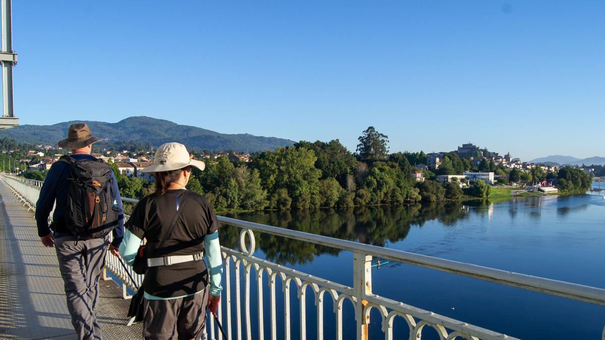 Pareja de pregrinos cruzando el puente internacional de Tui.