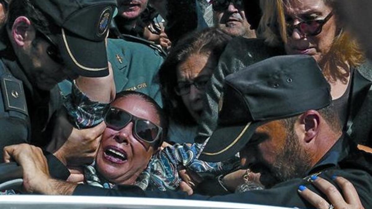 La policía trata de meter a Isabel Pantoja en su coche en medio del tumulto, ayer a su salida del Palacio de Justicia de Málaga.