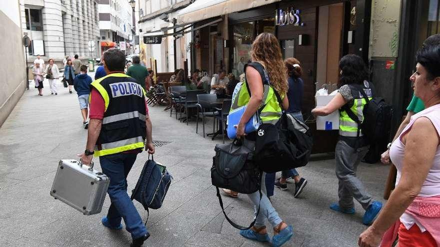 Agentes de la policía científica abandonan el piso con las pruebas ya tomadas. // Víctor Echave