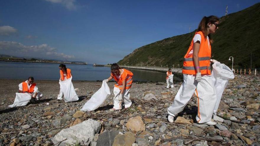 Un grupo de voluntarios, ayer, limpiando la playa Peña de Caballo, en las inmediaciones de la ría de Avilés.