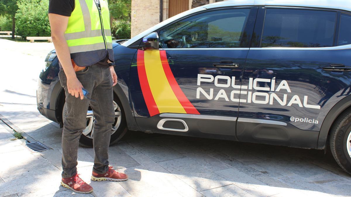 Un agente junto a un vehículo de la Policía Nacional.