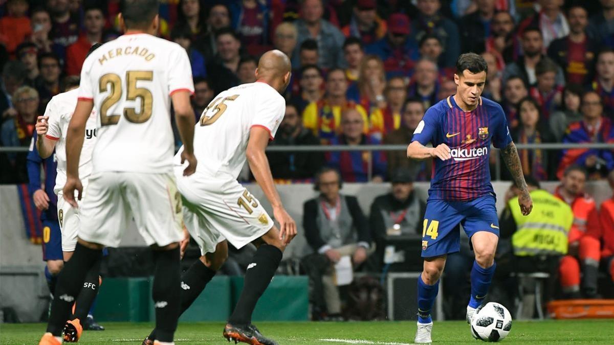 Coutinho conduce el balón ante Nzonzi y Mercado en el Metropolitano.