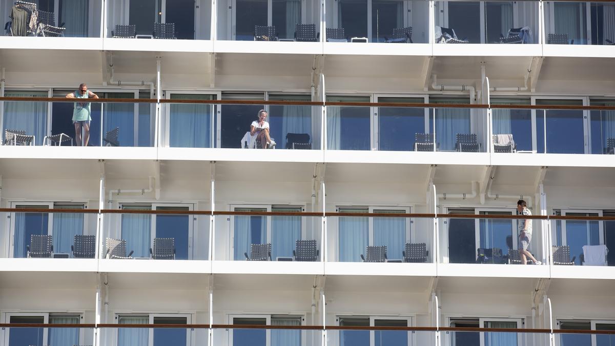 Pasajeros de un crucero en sus camarotes mientras el barco está amarrado en Alicante.