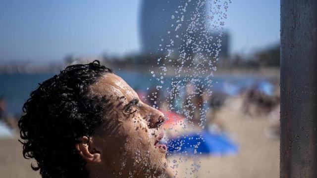 Un jove es refresca a la platja de la Barceloneta, la setmana passada. | FERRAN NADEU