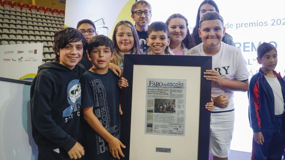 Os oito estudantes do CEIP Doutor Suárez e o su mestre, na recollida do premio. E á esquerda, a portada do seu xornal.   | // R.GROBAS