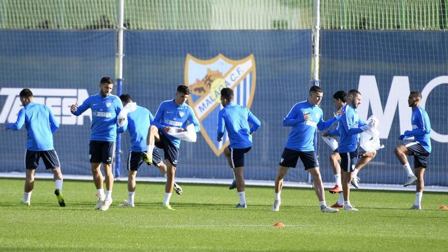 Los jugadores calientan en el Ciudad de Málaga.