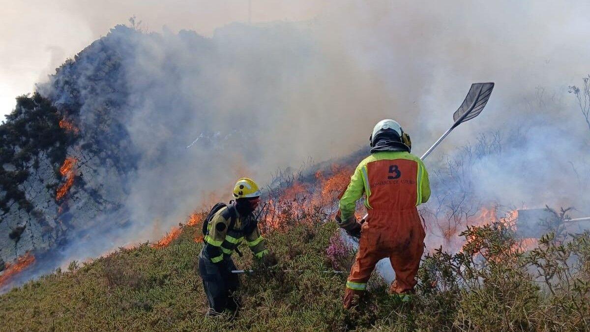 Dos bomberos luchan contra un incendio en Belmonte de Miranda.