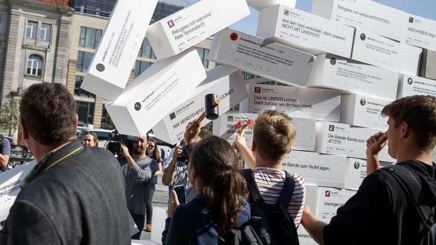 Activistas destruyen en Berlín un muro simbólico con mensajes de odio plasmados en las redes sociales.