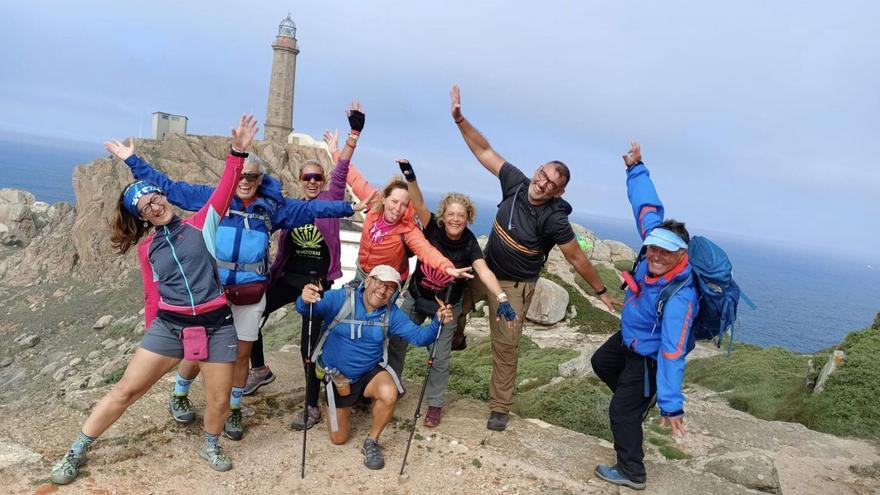 Un grupo de turistas frente al faro del Cabo Vilán, que en julio recibió 3.507 visitas