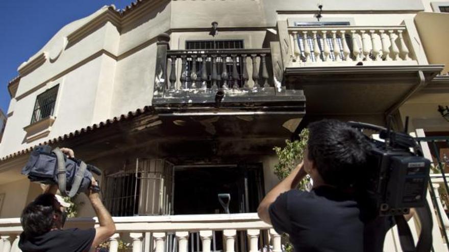 Varias cámaras de televisión toman imágenes del exterior de la vivienda situada en el número 19 de la calle Fuente de la Manía en Málaga, donde una mujer de 47 años ha fallecido esta madrugada en el incendio producido en el interior del inmueble.