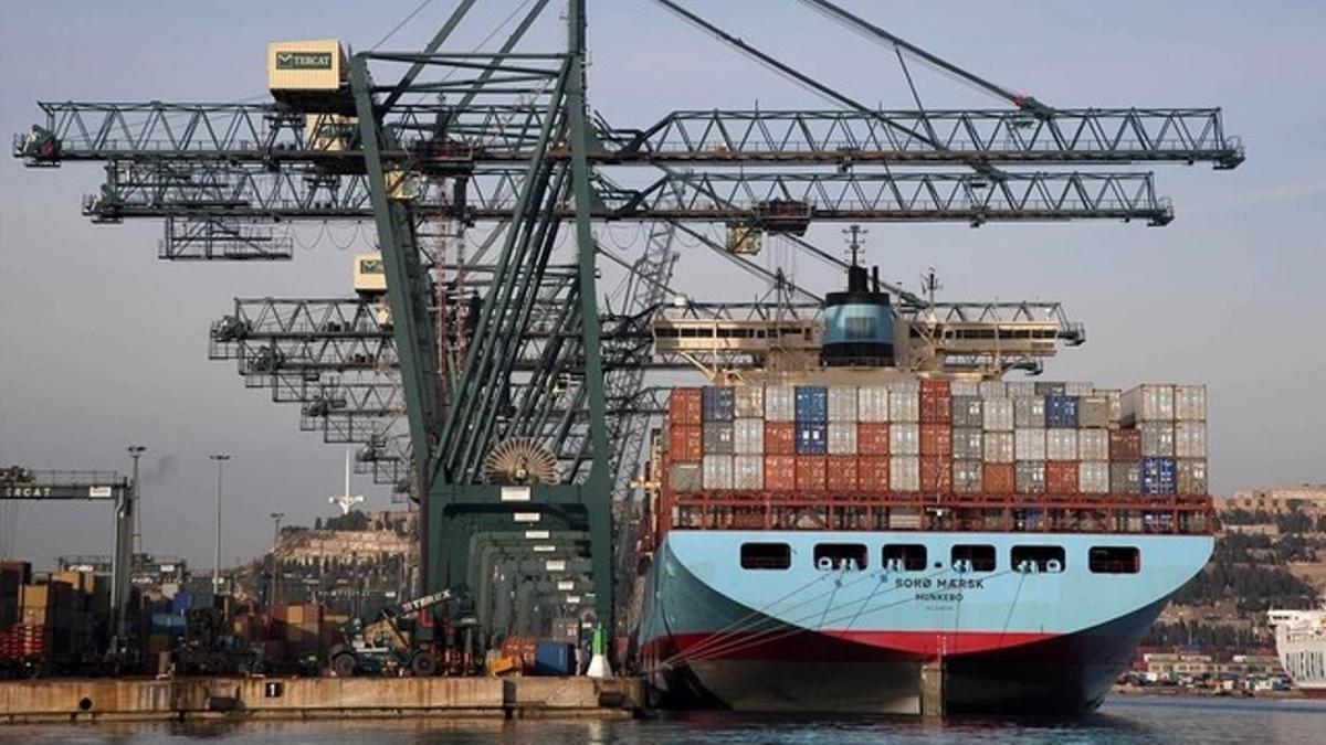 Un barco cargando contenedores en el puerto de Barcelona.