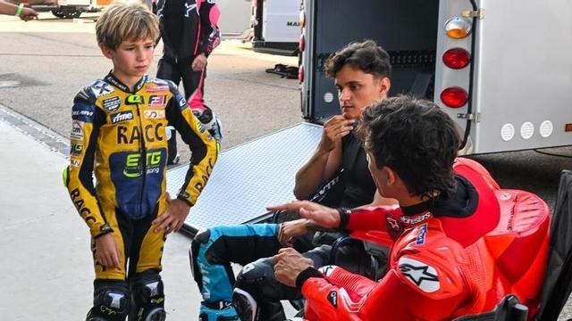 Marc Solés, de 9 anys, atén atònit els consells de Marc Márquez, dijous, a Motorland (Aragó)