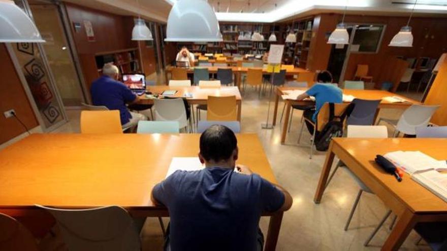 Usuarios de la Biblioteca central de Benidorm, leyendo o estudiando en la sala central, ayer al mediodía.