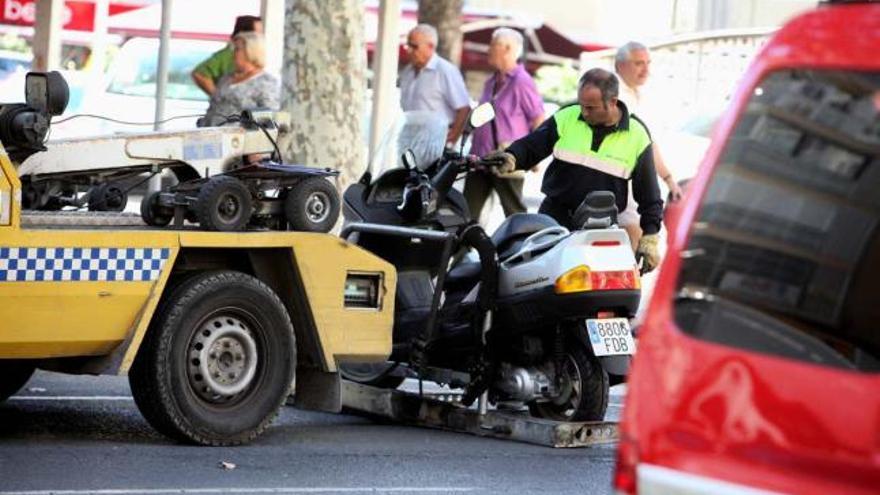 Un vehículo de la consesionaria retira una motocicleta en el centro de Benidorm.