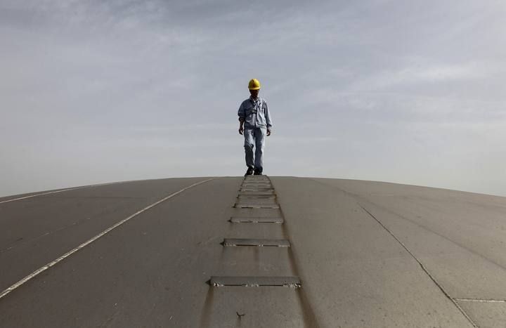 File picture of an employee walking on top of an oil tank at a Sinopec refinery in Wuhan, Hubei province