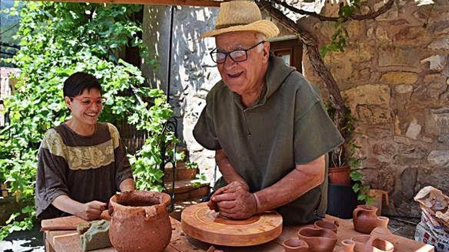 Marc Llordella modelant el fang al torn amb la seva deixebla Judit Puig al mercat medieval de Bagà, ahir