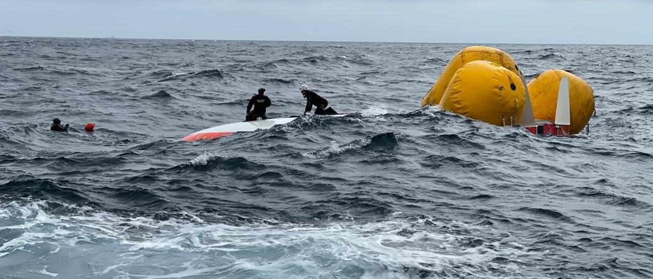 Dos de los buzos de salvamento marítimo que participaron en el rescate del pasado martes sobre el casco del velero.