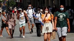 Paseantes con mascarilla por las calles del centro de Barcelona.