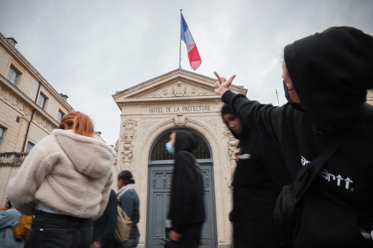 Los disturbios se extienden por Francia en la cuarta noche de protestas. Un manifestante señala con el dedo medio hacia el hotel de la prefectura durante una manifestación en Caen, noroeste de Francia