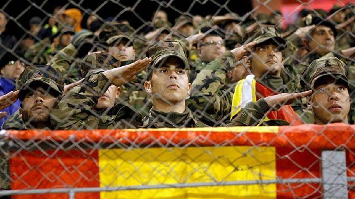 Soldados españoles escuchan el himno nacional en el estadio Bilino Polje, en Zenica