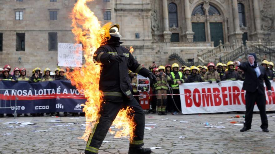 El bombero de Arousa al que otro, con la careta de Rueda, prendió fuego en la ‘performance’ de la manifestación en Santiago.  | // XOÁN ÁLVAREZ