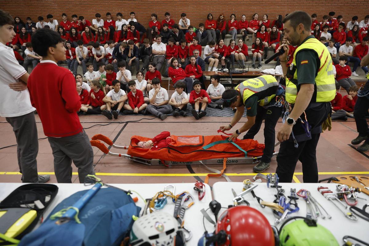 El Guardia Civil Steven Alejo agarrando a una de las alumnas del colegio en la camilla de transporte de heridos del GREIM.