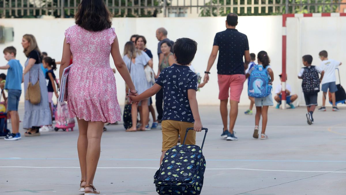 Un alumno con su madre en el primer día de curso.