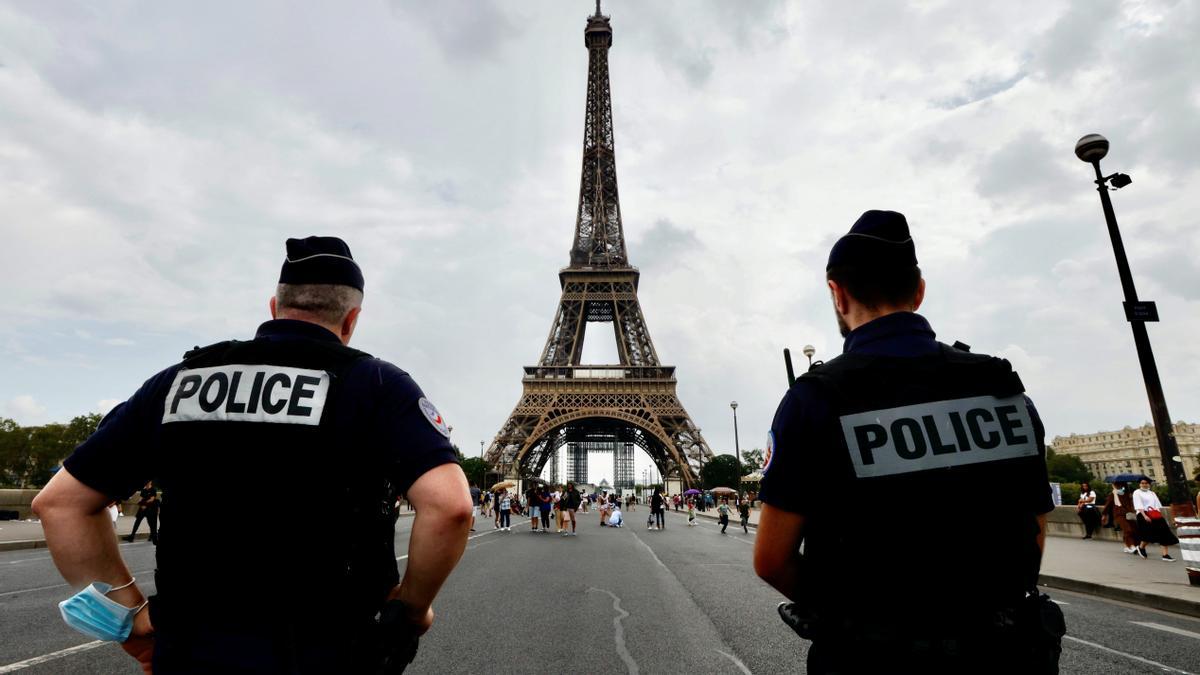 Oficiales de policía frente a la Torre Eiffel.