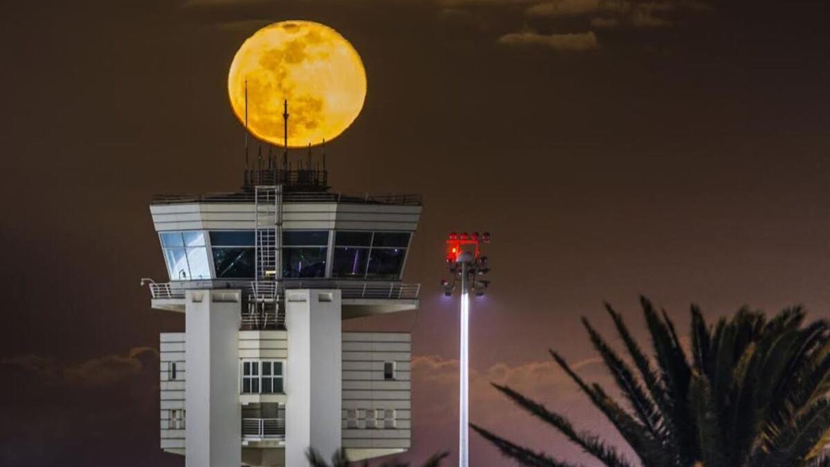 La Luna en fase llena saliendo detrás de la torre de control del Aeropuerto César Manrique Lanzarote en abril de 2021 y publicada en ATC MAGAZINE.